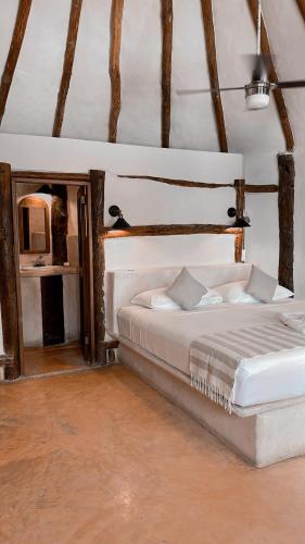 a bedroom with a large bed and a mirror at La Conchita Tulum in Tulum