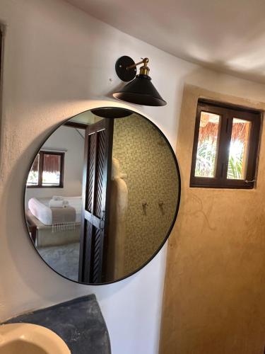 a mirror on the wall of a room with a bed at La Conchita Tulum in Tulum