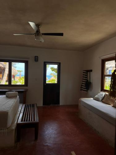 a bedroom with two beds and a ceiling fan at La Conchita Tulum in Tulum