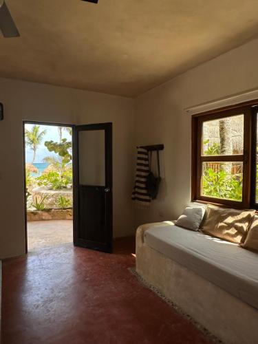 a bedroom with a bed and a large window at La Conchita Tulum in Tulum