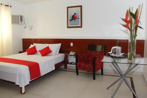 a bedroom with a bed and a table and a chair at HOTEL Casa cesar in Tumbes