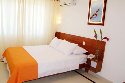 a bedroom with a bed and a phone in a room at HOTEL Casa cesar in Tumbes