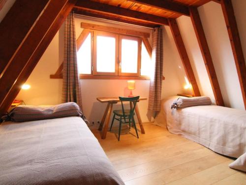 um quarto com duas camas e uma mesa com uma janela em Chalet Huez, 3 pièces, 6 personnes - FR-1-405-184 em LʼHuez