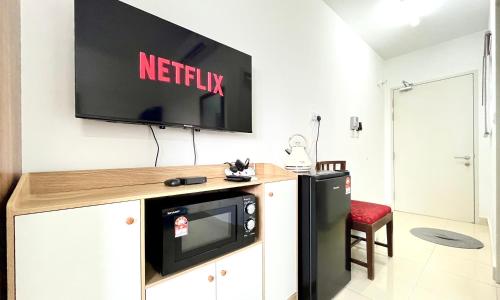 a television on a wall in a living room at Alanis Suite With Netflix @ KLIA Sepang in Sepang