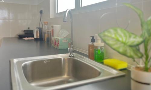 a stainless steel sink in a kitchen with a plant at Alanis Suite With Netflix @ KLIA Sepang in Sepang