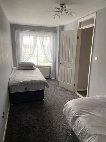 - une chambre avec 2 lits jumeaux et une fenêtre dans l'établissement Garland way 2 bed house Sheffield free parking 5 min from m1, à Mosborough