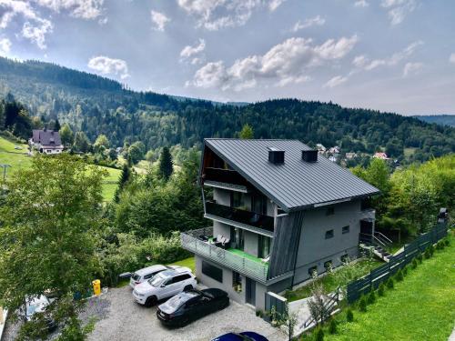 an aerial view of a house with two cars parked at Apartament Widoknastok in Korbielów