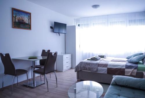 1 dormitorio con 1 cama, mesa y sillas en North&South Apartments en Zagreb