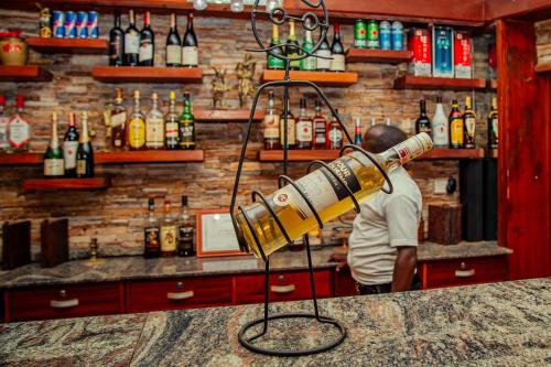 a man standing behind a bar with a telescope at Shangri-la Hotel Muyenga in Bugolobi