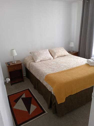 um pequeno quarto com uma cama e duas mesas de cabeceira em santiago centro em Santiago