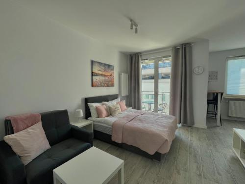 Ένα ή περισσότερα κρεβάτια σε δωμάτιο στο Studio Apartment Raspberry by Galeria Północna