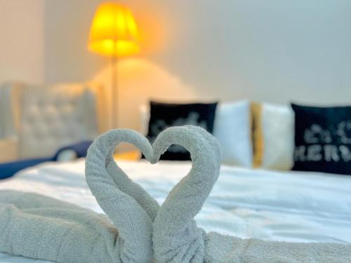 two towels in the shape of a heart on a bed at Alanis Suite With Netflix @ KLIA Sepang in Sepang