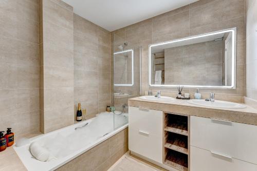 聖地亞哥港的住宿－Elegance Luxury Vacation House，带浴缸、水槽和镜子的浴室
