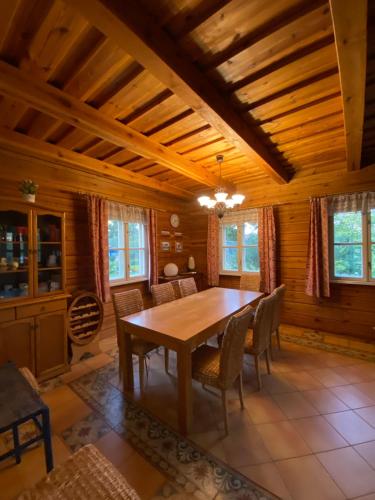 - une salle à manger avec une table et des chaises en bois dans l'établissement Baidarininkų vila pas Kazimierą, à Kaltanėnai