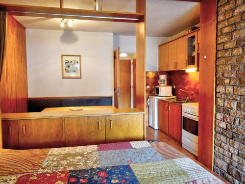 une cuisine avec des placards en bois et un mur en briques dans l'établissement Studio Morzine, 1 pièce, 4 personnes - FR-1-524-69, à Morzine
