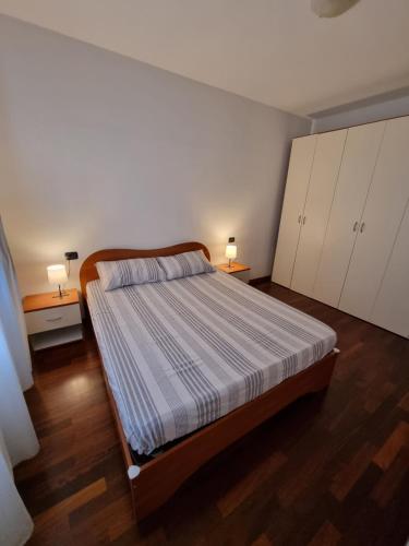 a bedroom with a bed and two lamps on two tables at Appartamento San Siro Stadio Fiera Milano City Life in Milan