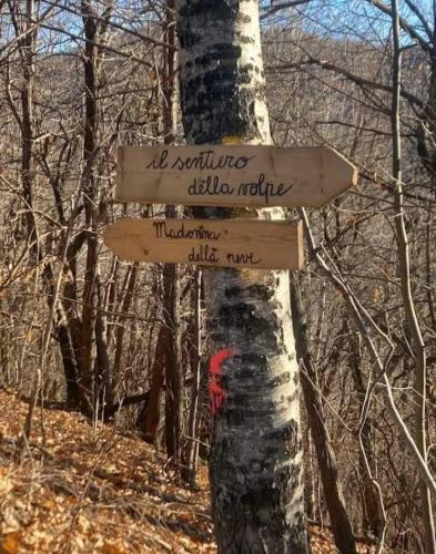 a sign on a tree in the woods at STARE BENE B&B in Bernezzo