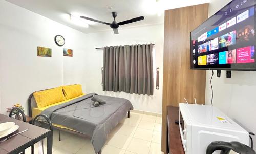 a living room with a couch and a flat screen tv at Alanis Suite With Netflix @ KLIA Sepang in Sepang