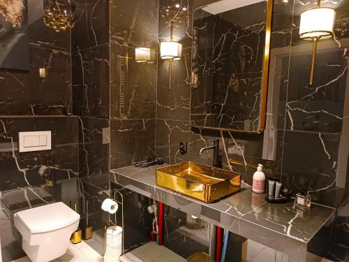 a bathroom with a toilet and a sink and a mirror at Apartamentylove - Apartament Żwirki, prywatny parking opcjonalnie in Łódź