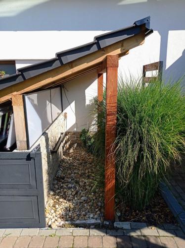 a wooden pergola next to a house at Penzion Mikulecký Kutloch in Mikulčice