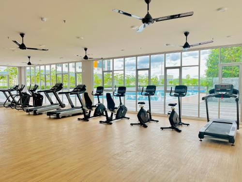 a gym with a row of treadmills and ellipticals at Alanis Suite With Netflix @ KLIA Sepang in Sepang