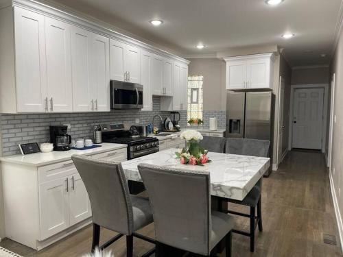 a kitchen with white cabinets and a table with chairs at Exec Lux home wth 3 Level,6 Bdrms/3bth & 2 Kitchen in Chicago