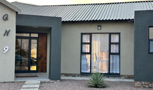 a house with glass doors and a metal roof at Sango on 9 in Naboomspruit