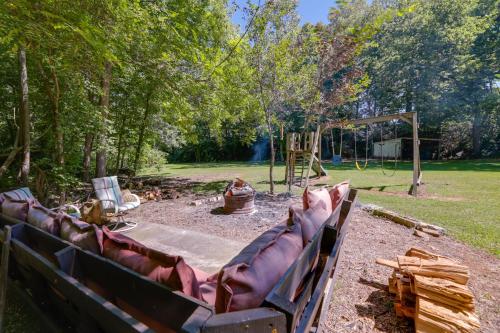 a couch in a backyard with a playground at Riverfront Covington Cabin with Deck and Fire Pit! in Piqua