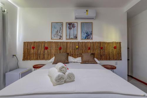 um quarto com uma grande cama branca com toalhas em Pousada Endlessenses em Itacaré