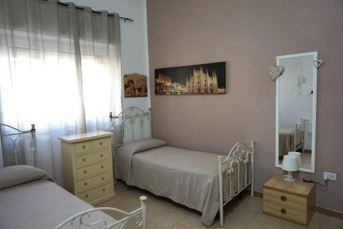 - une chambre avec 2 lits jumeaux et un miroir dans l'établissement Martina&Simone, à Campomarino