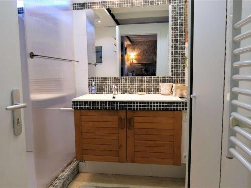 uma casa de banho com um lavatório e um espelho em Maison Trégastel, 1 pièce, 2 personnes - FR-1-368-211 em Trégastel