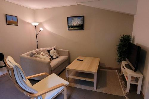 uma sala de estar com um sofá e uma mesa em Cosy flat with 180cm wide very comfortable bed em Sandefjord