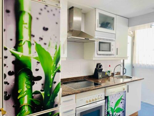 eine Küche mit Spüle und Herd Oberer Backofen in der Unterkunft Dúplex pareado con zona exterior in Navalcarnero