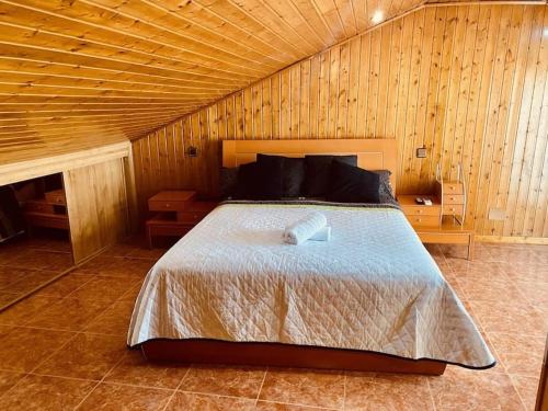 ein Schlafzimmer mit einem großen Bett in einem Holzzimmer in der Unterkunft Dúplex pareado con zona exterior in Navalcarnero