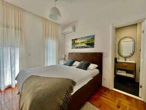a bedroom with a large bed and a mirror at Acacia Hills B1 in Đenovići