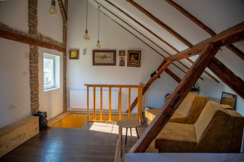 an attic room with a staircase and a chair at Apartmani Kačara in Sremski Karlovci