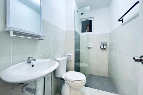 a white bathroom with a toilet and a sink at Alanis Suite With Netflix @ KLIA Sepang in Sepang