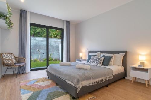 a bedroom with a large bed and a large window at Isaac Villa in Santa Cruz in Santa Cruz