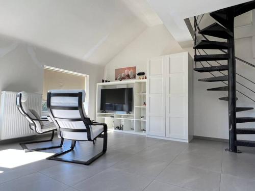 een woonkamer met 2 stoelen en een televisie bij Alexa Residence - Appartement 2 in Roeselare