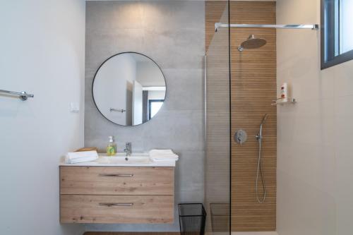a bathroom with a sink and a shower with a mirror at Isaac Villa in Santa Cruz in Santa Cruz
