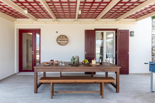 a wooden table with a bench on a patio at Aurora in Stelida