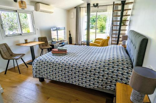 um quarto com uma cama, uma mesa e cadeiras em Studio indépendant, calme, avec parking privé et grand jardin, proche de Toulouse em Villeneuve-Tolosane