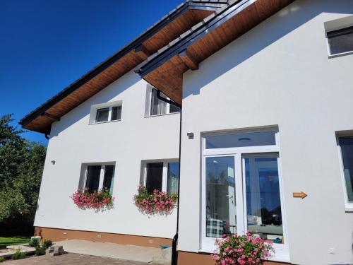 a white house with flowers in window boxes at Žiar Apartmány 43 in Žiar