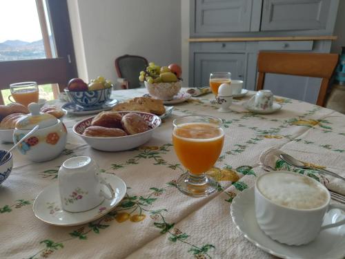 a table with breakfast foods and orange juice on it at B&b La Casa Nel Vento in Torpè