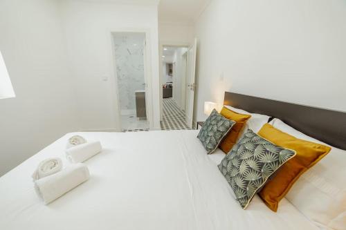 OPORTO GUEST Villa do Ribeirinho في بورتو: غرفة نوم مع سرير أبيض كبير مع وسائد ملونة