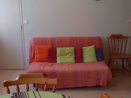 - un canapé avec des oreillers colorés dans l'établissement Appartement cosy T2bis pour 4-6 pers. à Cauterets, proche centre, parking gratuit, casier à skis, Est - FR-1-234-243, à Cauterets
