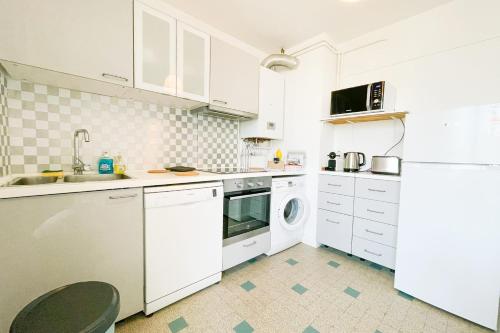a kitchen with white cabinets and a washer and dryer at #FV The art of living Clim Rénové in Saint-Martin-dʼHères