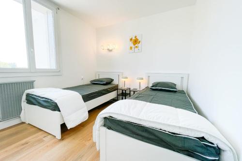 a white bedroom with two beds and a window at #FV The art of living Clim Rénové in Saint-Martin-dʼHères