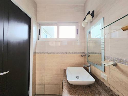 a bathroom with a toilet and a sink and a window at Piso 19 - Acogedor apartamento de 3 Recámaras in Panama City