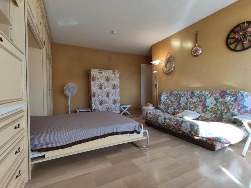 ein Schlafzimmer mit einem Bett und einem Sofa in der Unterkunft Appartement Antibes, 1 pièce, 3 personnes - FR-1-252-153 in Antibes